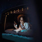 Romantisches Campervan-Leseerlebnis: Frau entspannt bei Sternenhimmel, WaterLamp sorgt für warmes Licht über ihrem Buch. Magische Nächte im Campervan – erlebe die romantische Beleuchtung im WaterLamp Shop!
